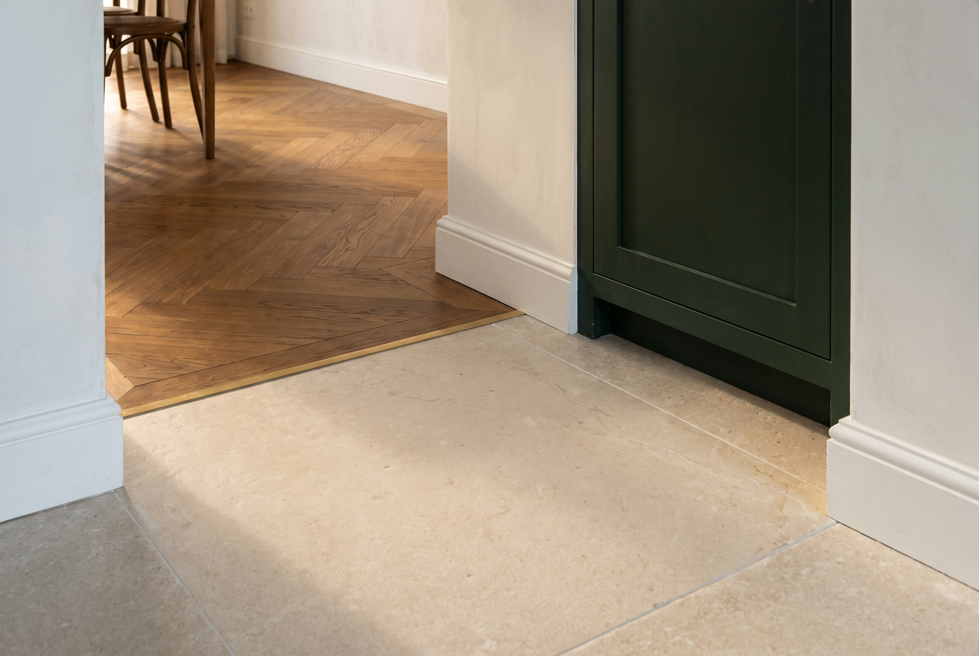 Kitchen tiles joined to herringbone parquet with a brass threshold, illustration
